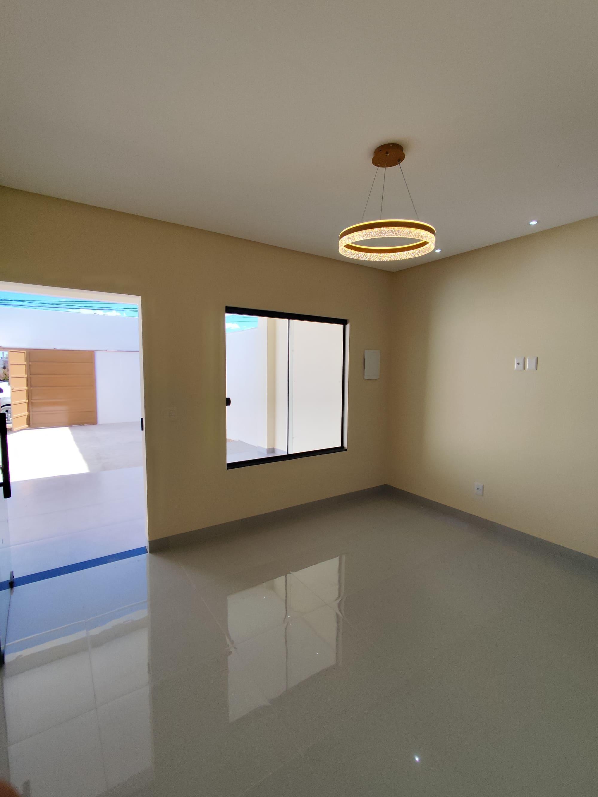 Sala de estar de imóvel com piso porcelanato e vista para a garagem