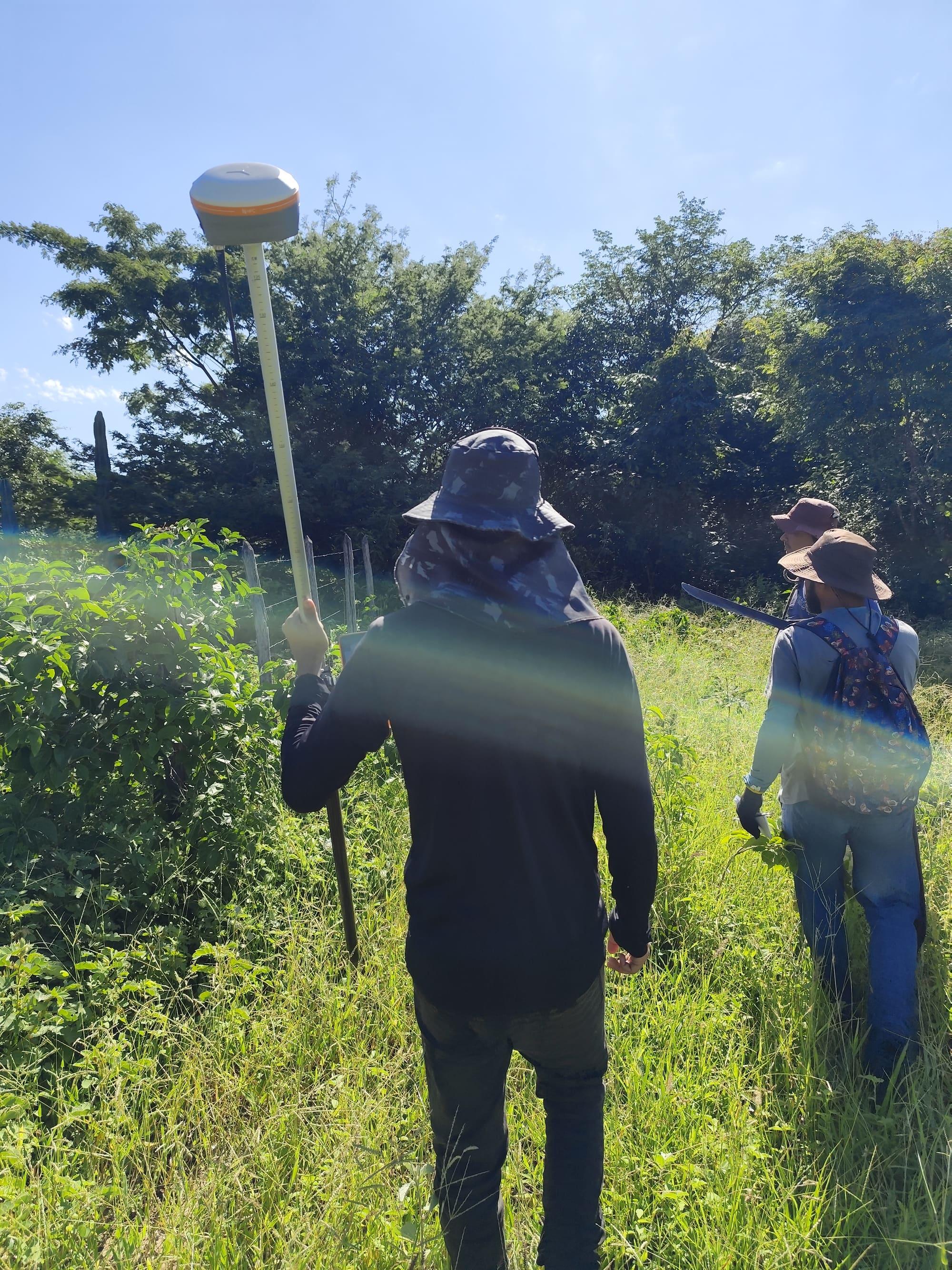 Equipe de topografia em campo durante levantamento em área de vegetação